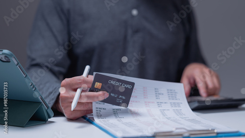 Photography Person reviews financial documents while holding credit card, importance of care