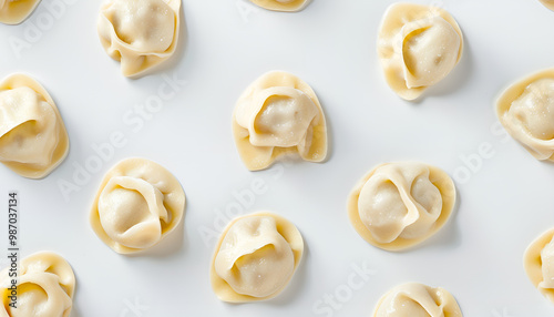 Many raw dumplings (varenyky) with potato on white background, top view