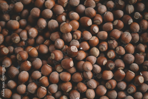 Hazelnuts in a wooden bowl on rustic background, Hazelnut background with green leaf