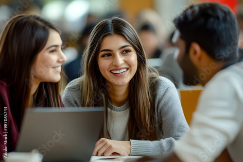 Cheerful business colleagues working on agreements, smiling and laughing while completing paperwork together, enjoying teamwork in a diverse and successful office environment