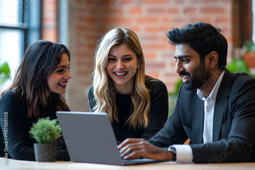 Successful business professionals reviewing legal and financial reports, discussing agreements at the laptop, working together on paperwork, smiling, and laughing in a friendly, productive meeting