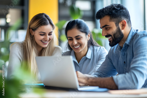 Successful diverse business team reviewing legal and financial documents, discussing an agreement at the laptop, smiling and laughing while doing paperwork together in a collaborative environment