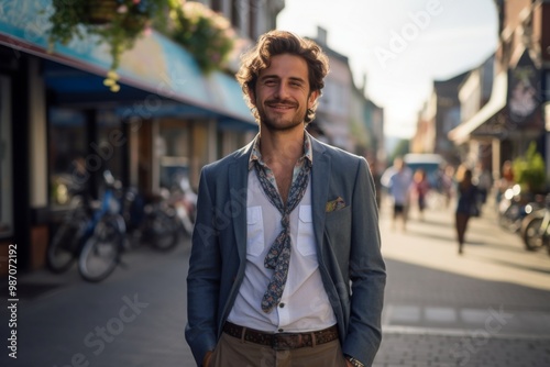 A man in a blue jacket and white shirt is smiling for the camera