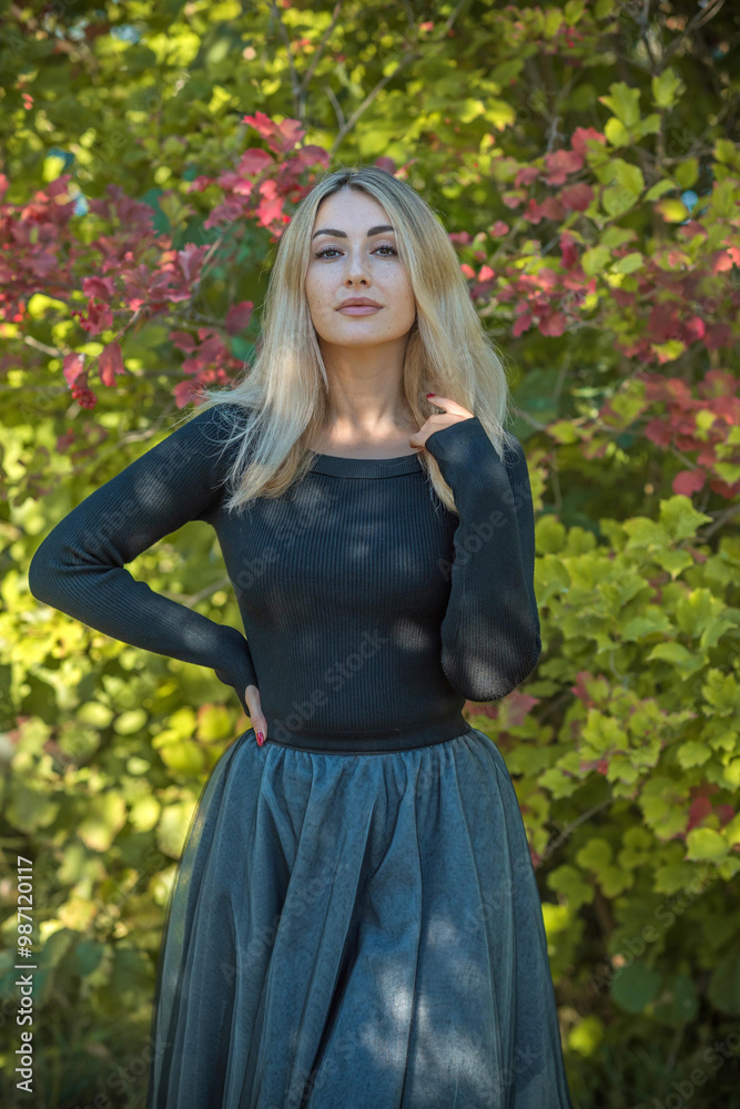 Elegant woman in black tones standing outdoor in garden. Beautiful feminine look Elegant woman in black tones standing outdoor in garden. Beautiful feminine look