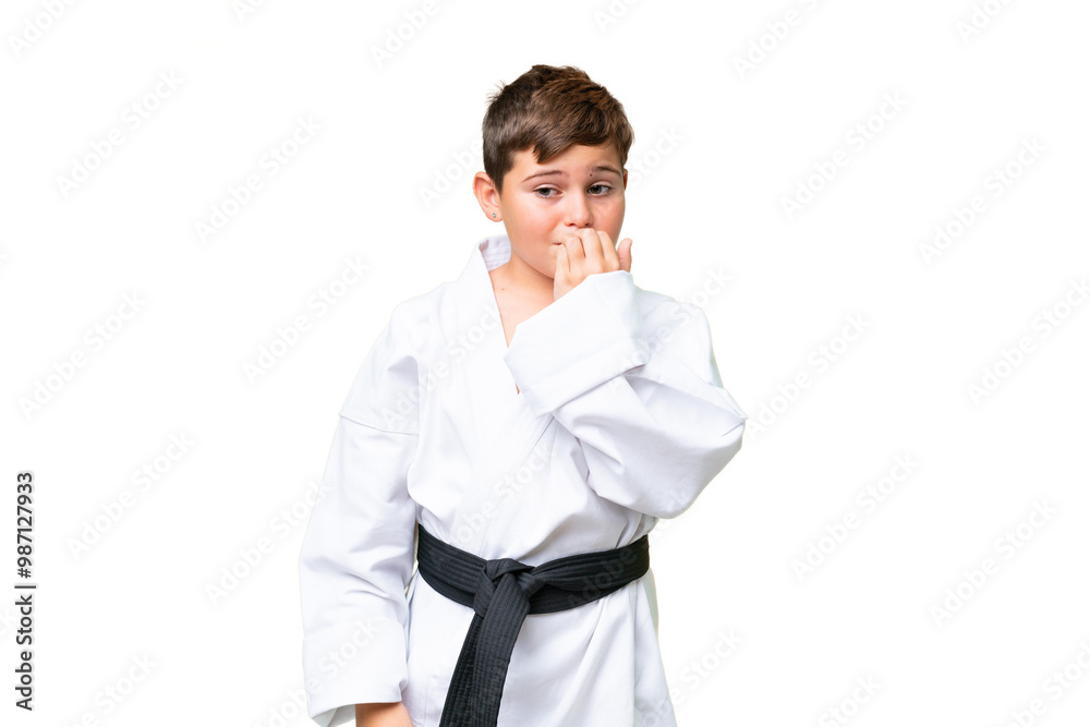 Little caucasian kid doing karate over isolated chroma key background having doubts Little caucasian kid doing karate over isolated chroma key background having doubts