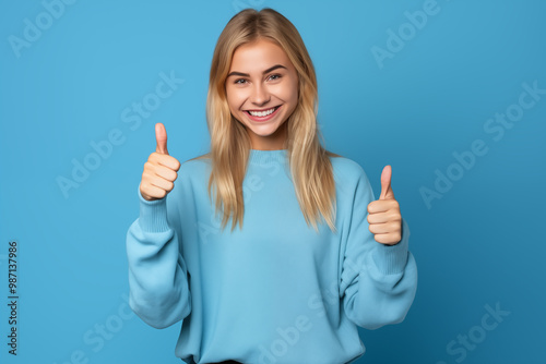 Young pretty blonde girl over isolated colorful background with thumb up