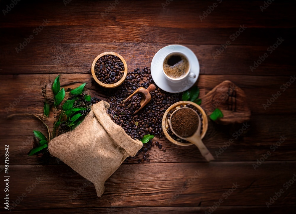 Coffee beans, ground coffee, a cup of coffee and a burlap sack on a wooden table. Coffee beans, ground coffee, a cup of coffee and a burlap sack on a wooden table.