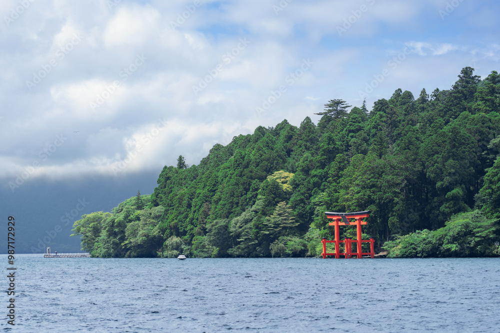 Beautiful serene lake with lush green forest and torii gate