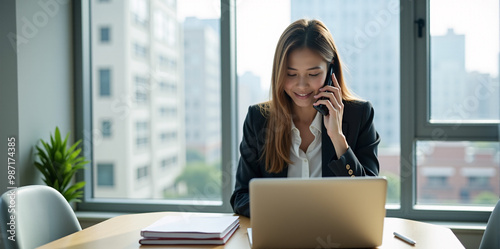 A  business woman is discussing a new strategy over the phone in a bright and productive office (with copy space).
