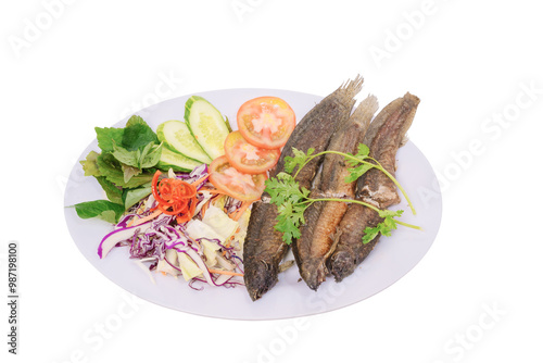 a plate of crispy fried loach accompanied by fresh vegetables, presenting an appealing and colorful meal setup. The dish looks delicious and well-prepared, perfect for a hearty meal.