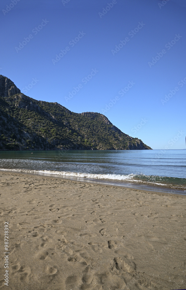 Looking out over the mediterranean from Iztuzu beach in Turkiye. Shallow sandy beach with mountainous headland. Looking out over the mediterranean from Iztuzu beach in Turkiye. Shallow sandy beach with mountainous headland.