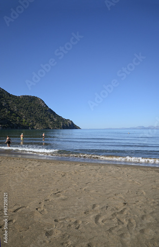 Fototapeta Naklejka Na Ścianę i Meble -  Looking out over the mediterranean from Iztuzu beach in Turkiye. Shallow sandy beach with mountainous headland.