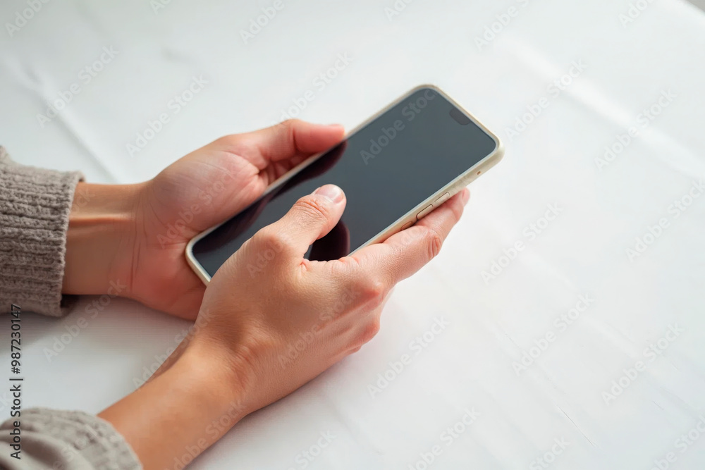 Hands holding a smartphone with a blank screen isolated on black background, perfect for technology and communication themes Hands holding a smartphone with a blank screen isolated on black background, perfect for technology and communication themes