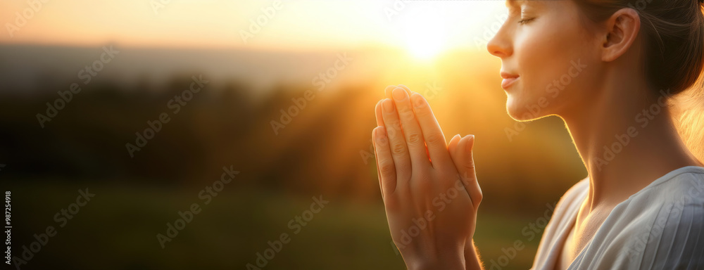 A woman praying peacefully at sunrise, bathed in warm light, symbolizing gratitude and hope for a new beginning.