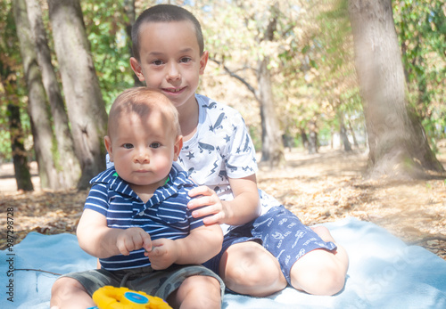 Brothers sitting in the park. Boy about 7 years and baby about 8 months. photo