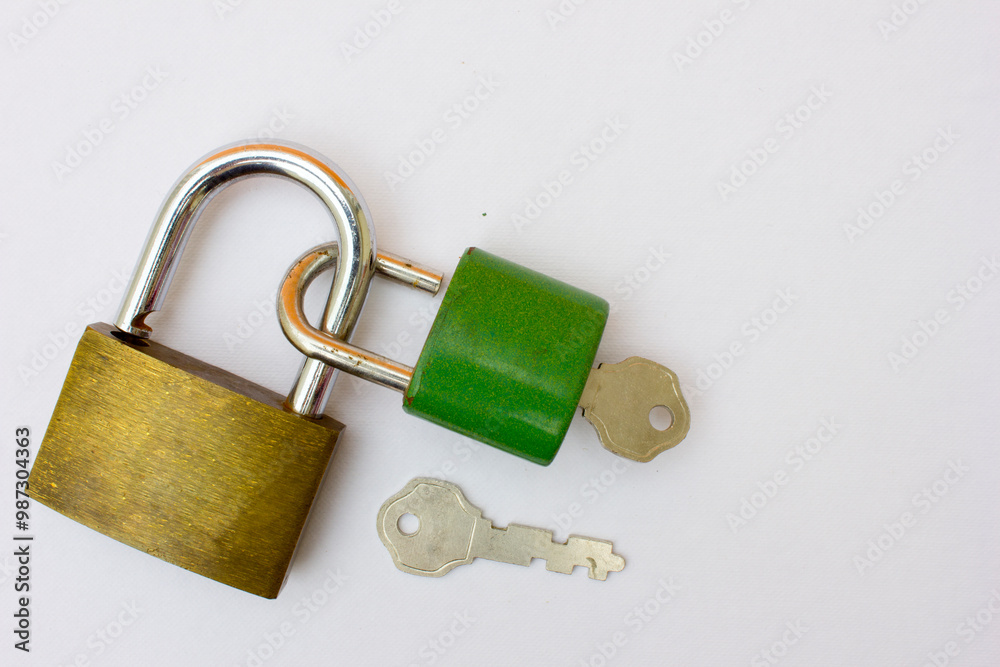 A golden padlock and a green padlock with their respective keys are intertwined. This photo is symbolic of a strong bond. A golden padlock and a green padlock with their respective keys are intertwined. This photo is symbolic of a strong bond.