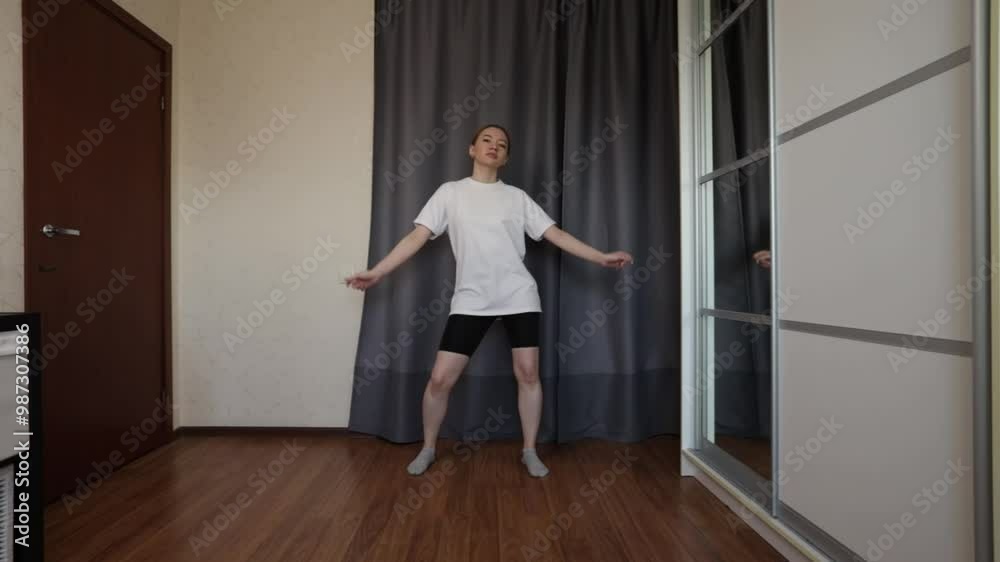 Teenager learning to dance, young woman doing exercises, student practicing motion indoors, having fun Teenager learning to dance, young woman doing exercises, student practicing motion indoors, having fun