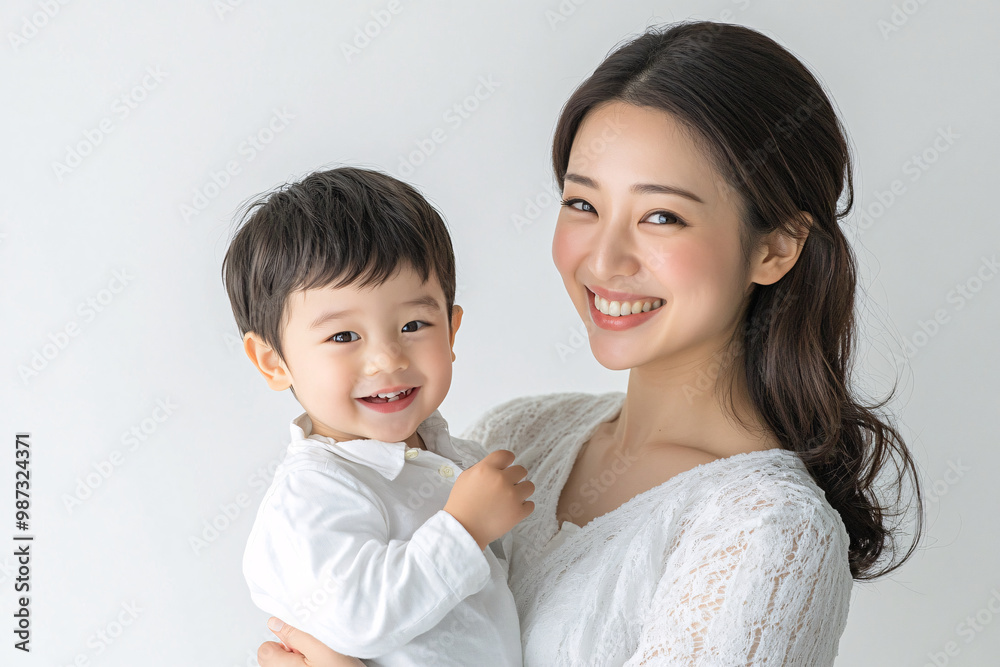 Young Japanese mother holding her cute young son, both looking into the camera, in front of a white studio background, showcasing a tender moment of family bonding and love Young Japanese mother holding her cute young son, both looking into the camera, in front of a white studio background, showcasing a tender moment of family bonding and love