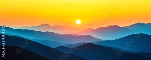 Vibrant sunrise over layered mountain ranges with a golden sky and misty blue hues, creating a serene and picturesque landscape.