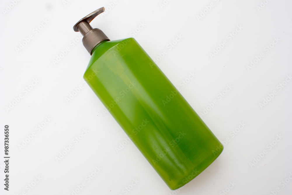 A green plastic shampoo bottle with a brown cap. A green plastic shampoo bottle with a brown cap.