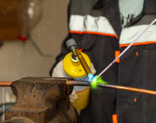 Konstfotografi worker soldering copper pipes with a gas torch