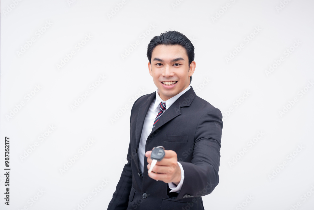 Smiling car salesman handing over keys to a customer Smiling car salesman handing over keys to a customer