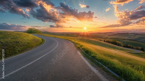 Landscape of a road stretching across a grassland with a sunset view