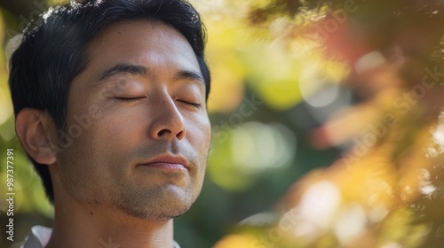 Close-up of an Asian man meditating in a peaceful garden, finding inner peace and clarity amidst nature.