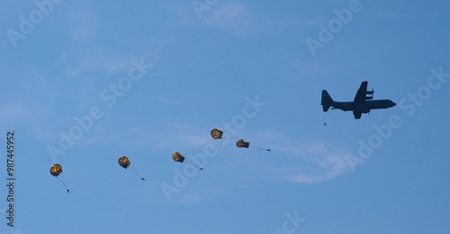 air force military paratroopers dropping from a propellor plane. photo