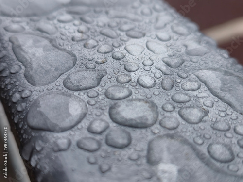 Water drops on a metal surface close view, raindrops on a fence photo