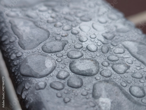 Water drops on a metal surface close view, raindrops on a fence photo