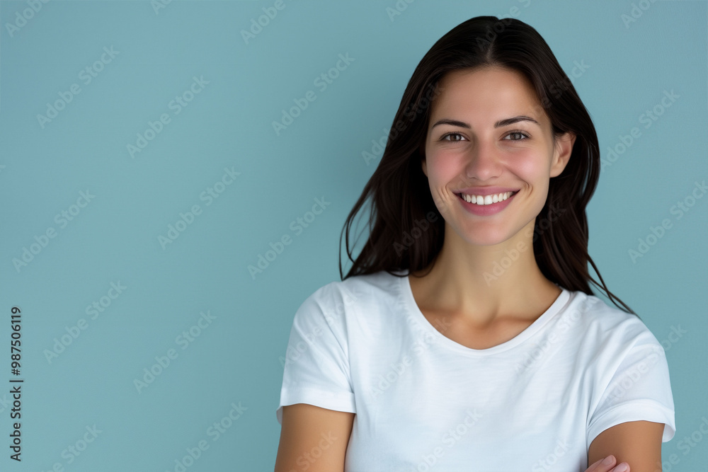Confident Woman in White T-Shirt Smiling Against Blue Background - Professional Portrait Confident Woman in White T-Shirt Smiling Against Blue Background - Professional Portrait