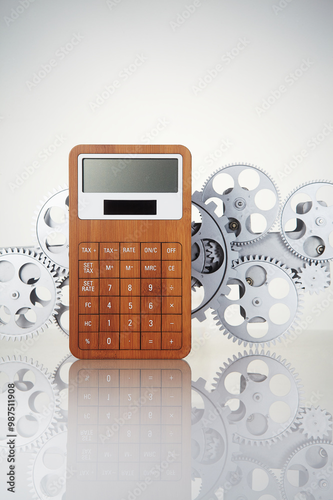 Calculator and gear wheel on a white background.