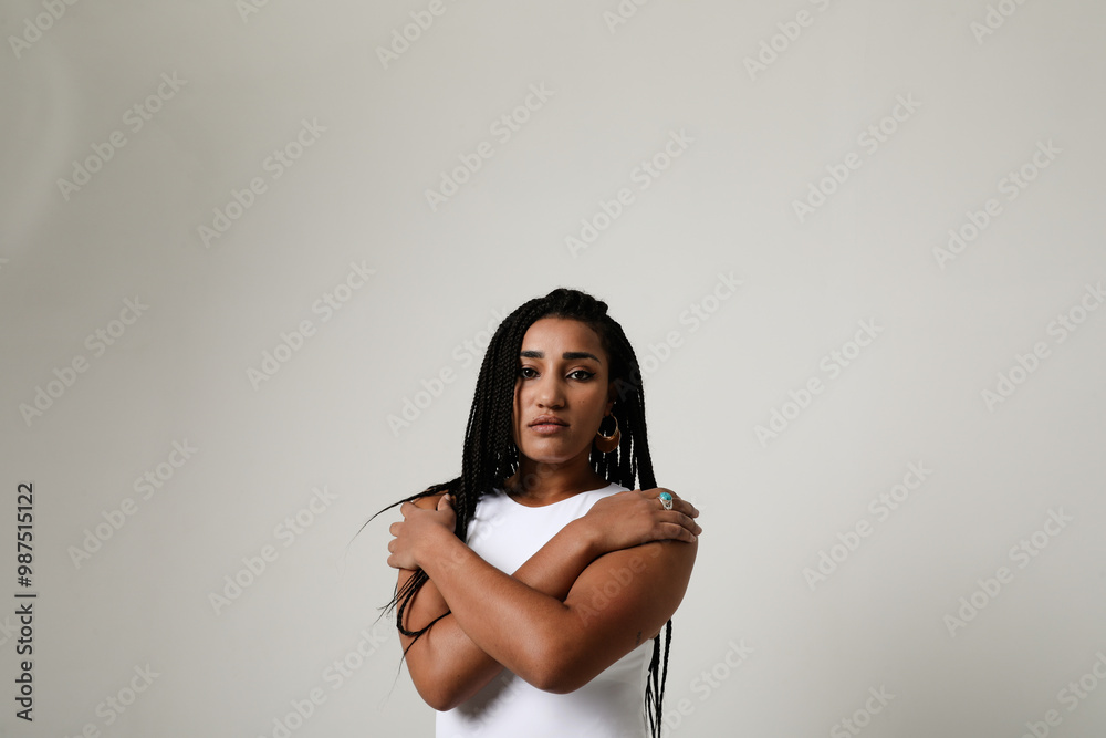 Fototapeta premium Mind set. Young dark-skinned woman with long dark braids posing indoor.