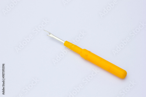 A seam ripper is a small sewing tool used for cutting and removing stitches. The most common form consists of a handle, shaft, and head.