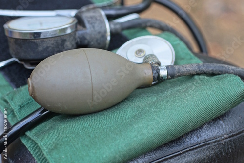 medical tonometer pressure meter with rubber bulb lie on green fabric and the ground on a summer street photo