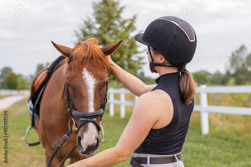 Female rider hand gently caressing beautiful thick red horse mane, close up shot. Equitation and animal lover concept.