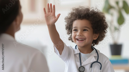 A cheerful young boy enthusiastically high-fiving a welcoming pediatrician at his doctor's appointment, showcasing a positive experience. photo