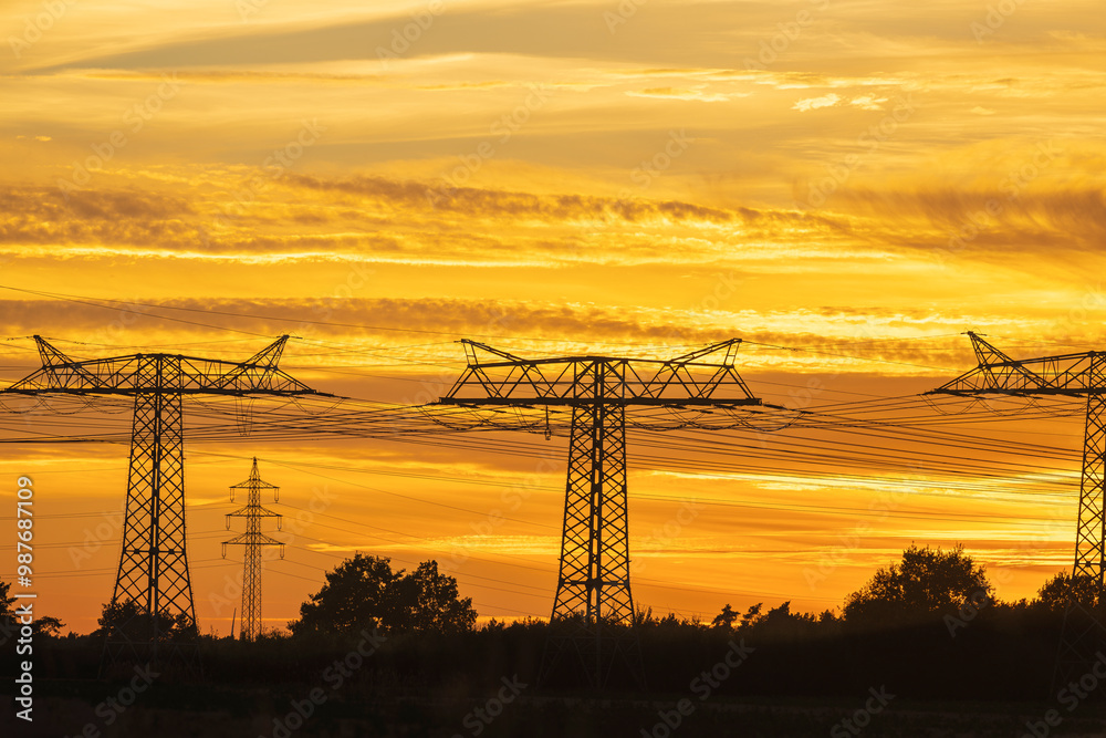 Strommasten einer Freilandleitung bei Sonnenuntergang