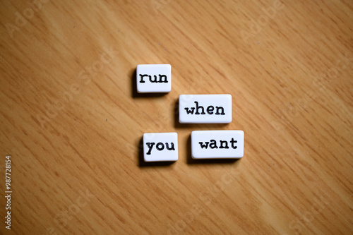 Motivational expression: Joyful expression: blocks with the words 'run', 'when', and 'want' placed on a wooden surface.