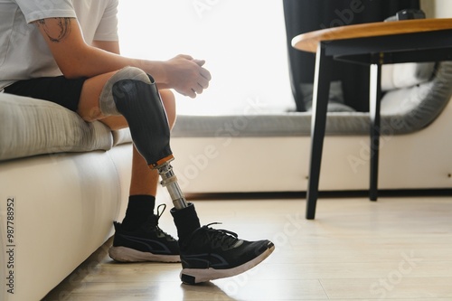 Closeup of unrecognizable man with bionic prosthetic leg at home indoors, copy space