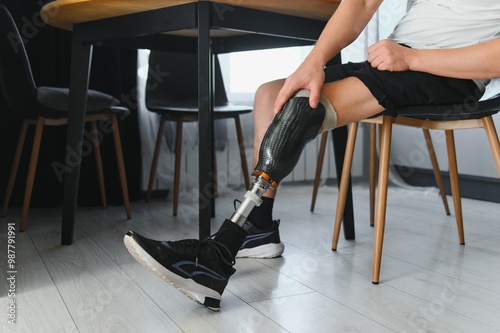 portrait of man with prosthetic leg sitting photo