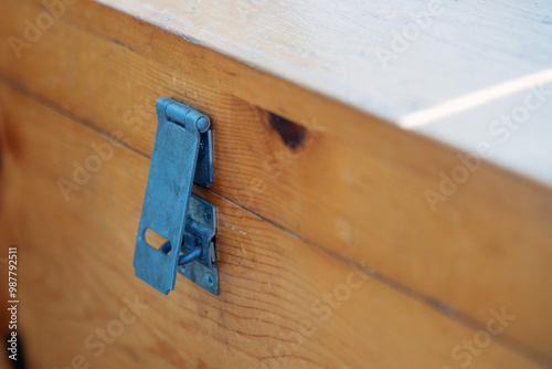 aged metal hasps for a padlock, affixed to a weathered wooden chest, symbolizing secrets buried in time and the allure of forgotten treasures
