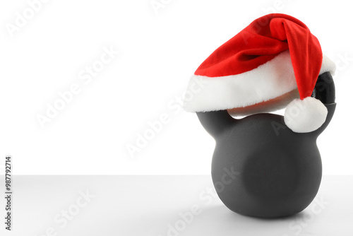 Kettlebell with red Santa Claus hat isolated on white photo