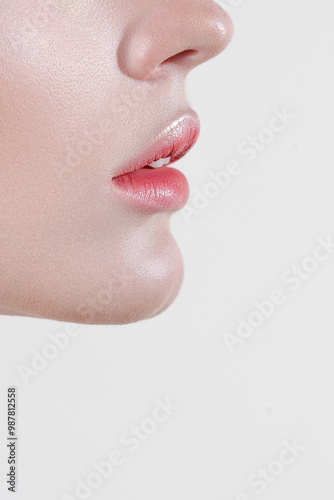 Lips and chin of young sensual woman with clear glowing skin closeup in profile