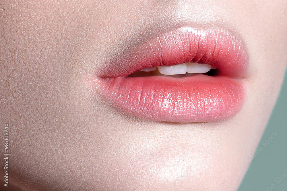 Naklejka premium Lips of young sensual woman with clear glowing skin closeup