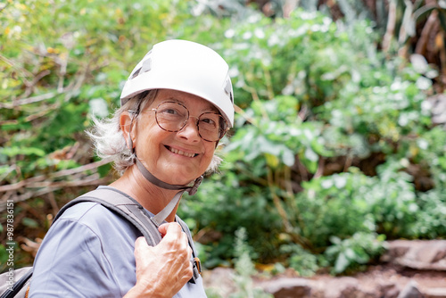 Portrait of smiling senior hiker woman wearing protective helmets walking on mountain excursion enjoying freedom and nature. Freedom, success sport concept photo