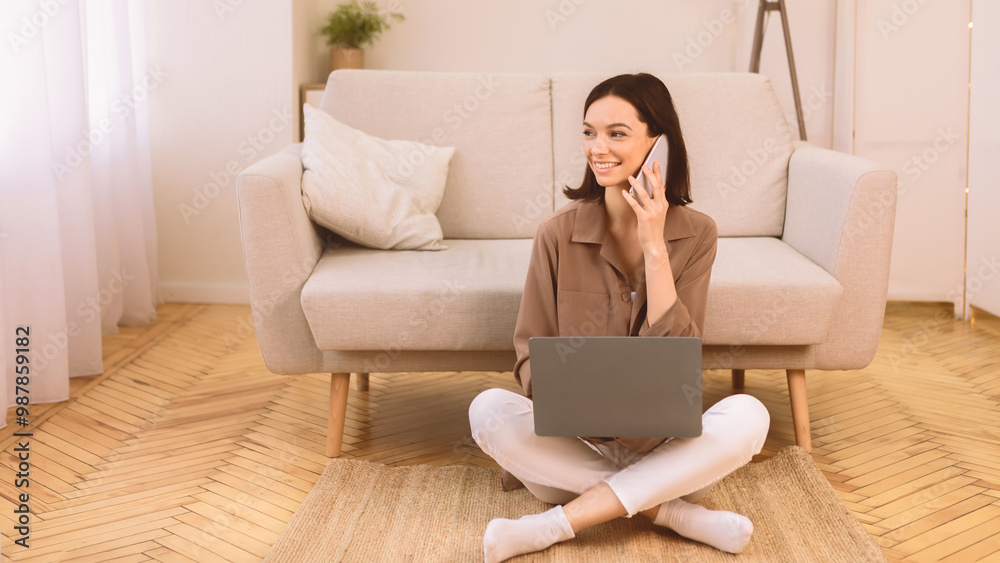 Freelance Career. Young Woman Talking On Cellphone Using Laptop Sitting On Floor At Home Looking Away. Copyspace Freelance Career. Young Woman Talking On Cellphone Using Laptop Sitting On Floor At Home Looking Away. Copyspace