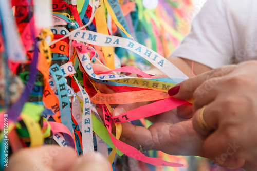 Catholics are seen tying colorful ribbons as souvenirs at the gate of the Senhor do Bonfim church in Salvador, Bahia. photo