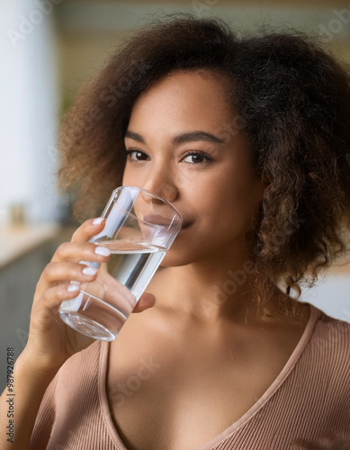 Closeup image of a beautiful young asian woman holding a glass of water to drink 